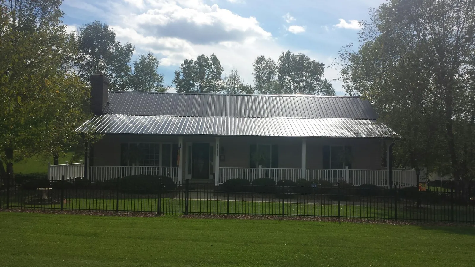 Gray metal roof on a brick ranch with a full width front porch — Gutter Guard Installation work by our crew in Eglin Afb
