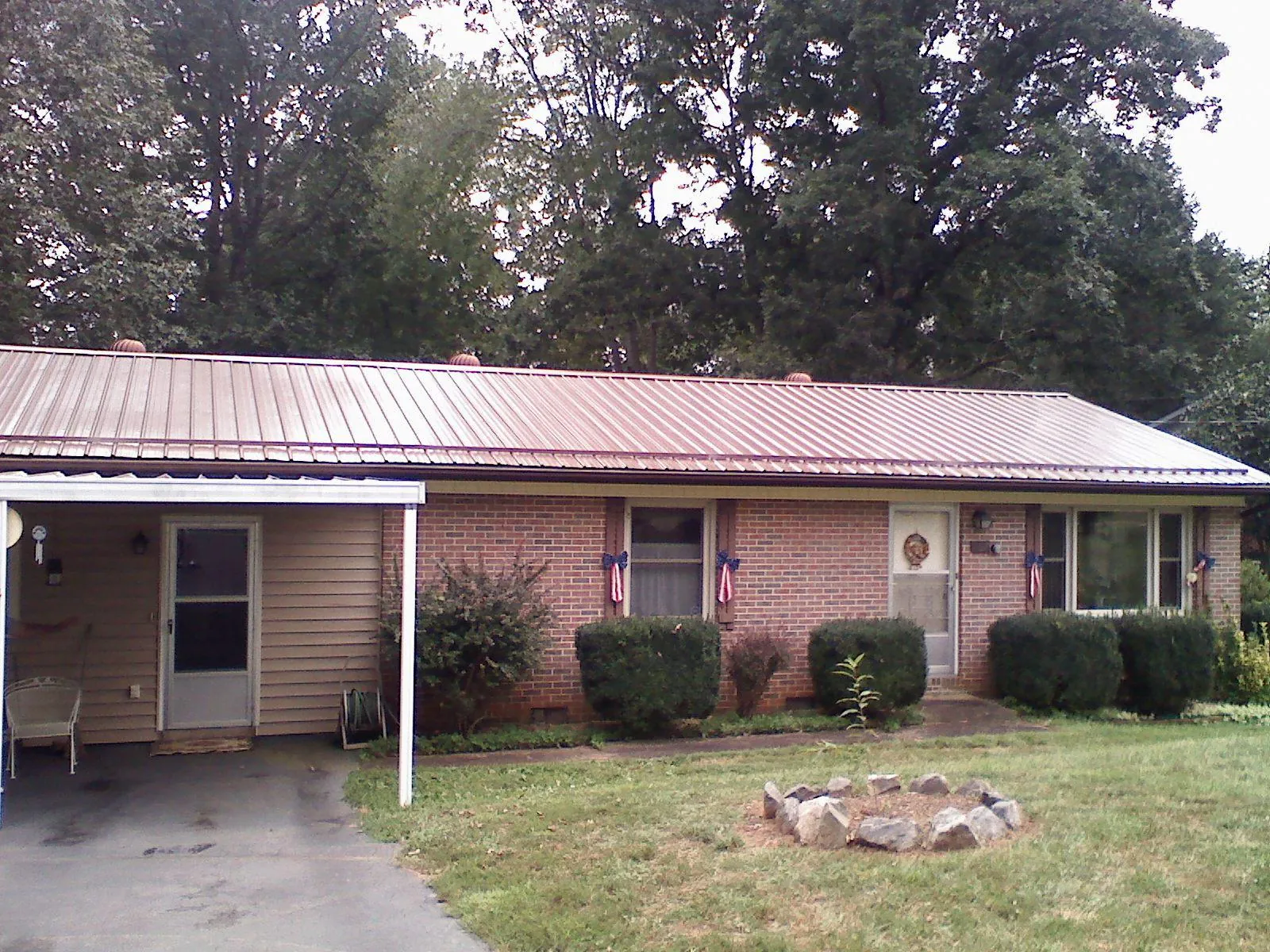 Bronze metal roof and carport on a brick ranch home — Roof Repair work by our crew in Eglin Afb