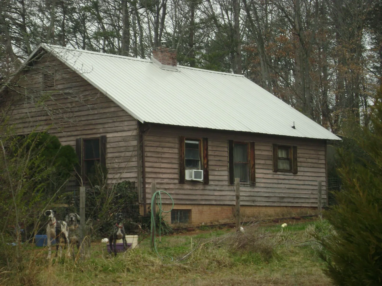 White metal roof on an old wood sided farmhouse, from a Metal Roof Installation job in Eglin Afb
